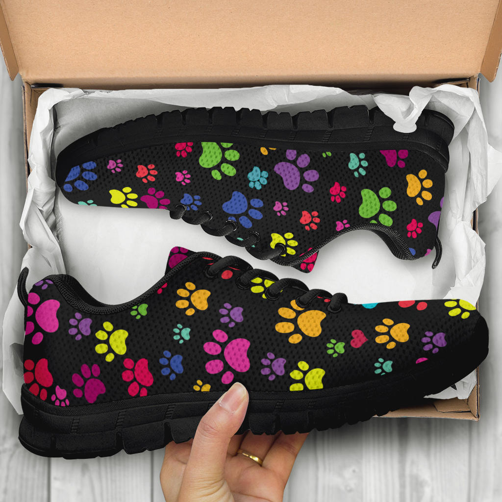 Unboxing Colorful Paws Sneakers with black soles, showing the paw print themed shoes inside a cardboard box.