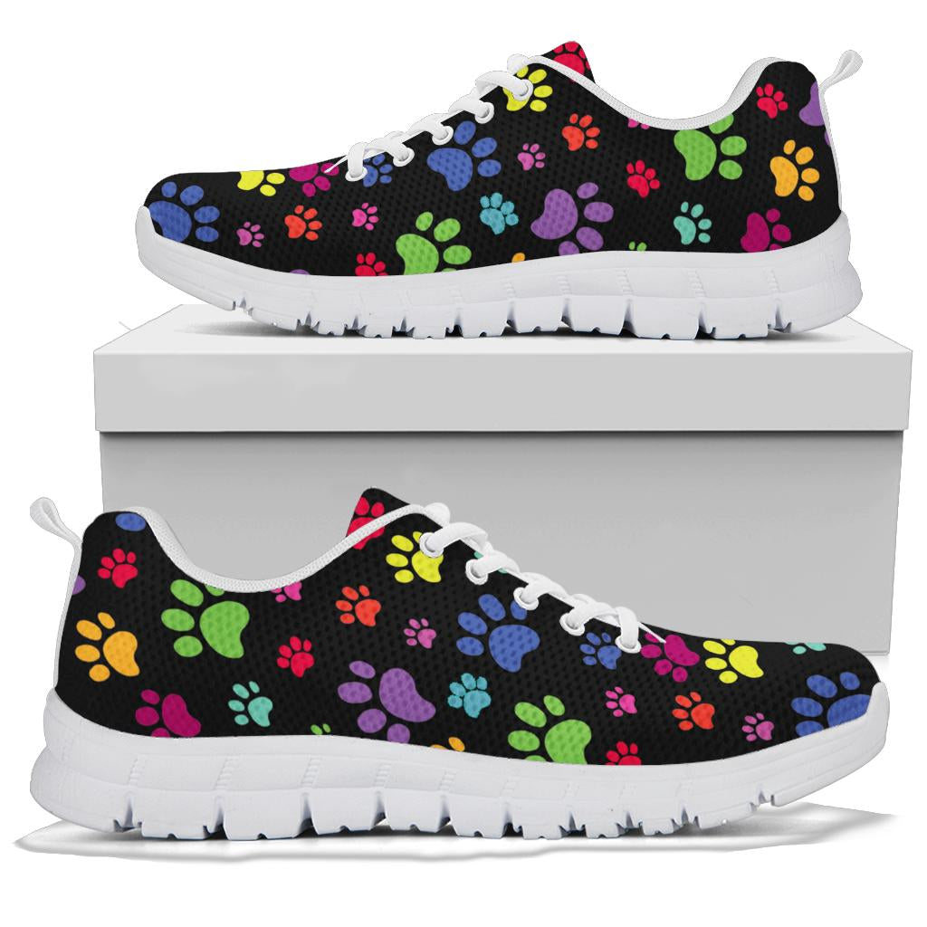 A pair of Colorful Paws Sneakers with white soles and white laces, displayed resting on top of a plain white shoe box.